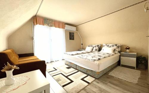 1 dormitorio con cama y ventana grande en Heilmann Ház, en Harkány