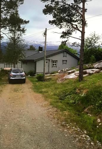 une voiture garée devant une maison dans l'établissement Perlen på solheim I Hyen, à Vereide