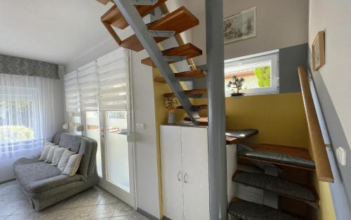 a living room with a staircase and a chair at Heilmann Ház in Harkány