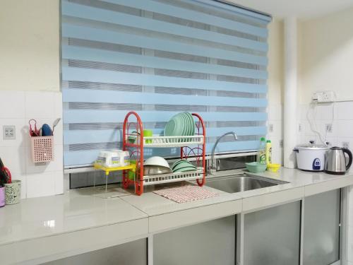 un bancone della cucina con stendibiancheria accanto a un lavandino di Gallata Two Bedroom Street View a Port Dickson