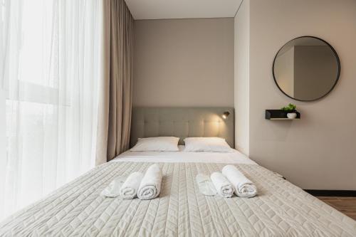 a bedroom with a bed with three towels on it at Aura Home in Dnipro
