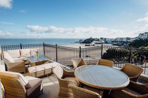 a balcony with a table and chairs and the ocean at Ocean House, Tenby in Tenby