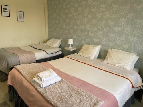 two beds in a hotel room with towels on them at Liber Guest House in Braga