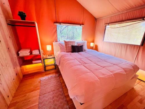 a bedroom with a large bed in an orange room at Tropical glamping with hot tub in Cleveland