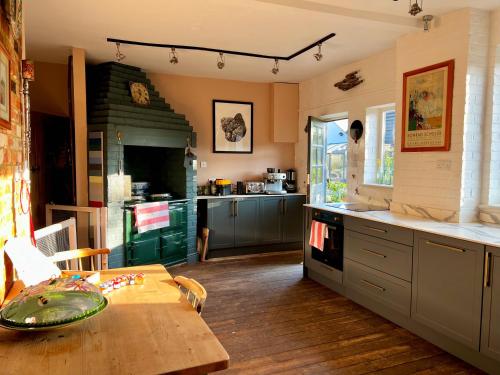 uma cozinha com uma mesa e uma cozinha com um fogão em Quirky Luxury Barn Sleeps 8, Pet Friendly em Calne