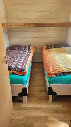2 Betten in einem Zimmer mit Holzböden in der Unterkunft lodge sibylle in Soubey