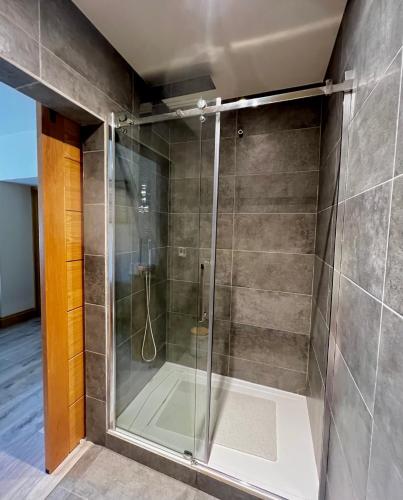 a shower with a glass door in a bathroom at Eclectic Barn - Pergola & Dog-Friendly Garden in Calne