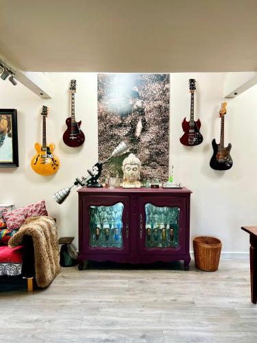 a living room with guitars on the wall at Eclectic Barn - Pergola & Dog-Friendly Garden in Calne