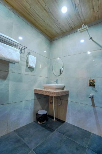 a bathroom with a sink and a mirror at SaffronStays Kesar Villa, Manali - beautiful villa amidst an apple orchard - All clear roads in Manāli