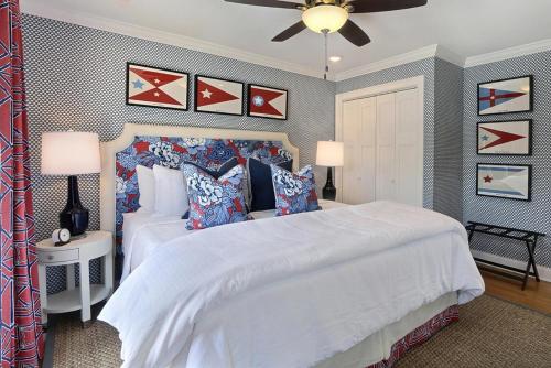 um quarto com uma grande cama branca e uma ventoinha de tecto em El Rey Collection 2 em Tybee Island