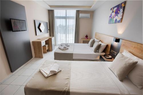 a hotel room with a large bed and a table at Alanya Risus Park Hotel in Alanya