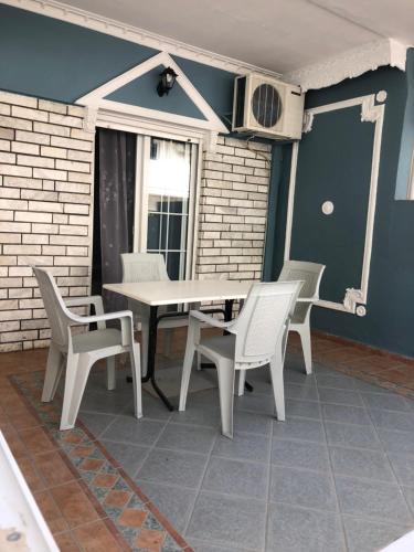 a patio with a table and chairs on a porch at Olympus Apartments in Paralia Katerinis