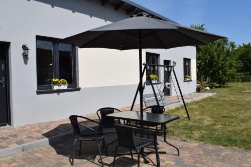 a table and chairs with an umbrella on a patio at Apartament Domowe Zacisze 1 in Choczewo