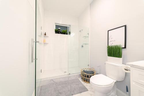a white bathroom with a shower and a toilet at The East Rock, 4BR, On-site Parking, Washer & Dryer, Walk to Yale in New Haven