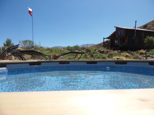 a large swimming pool in front of a house at Tierras Bayas Mountain Refuge in Los Cipreses