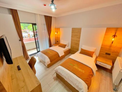una camera d'albergo con due letti e una televisione di EYMEN APARTMENTS a Uzungöl