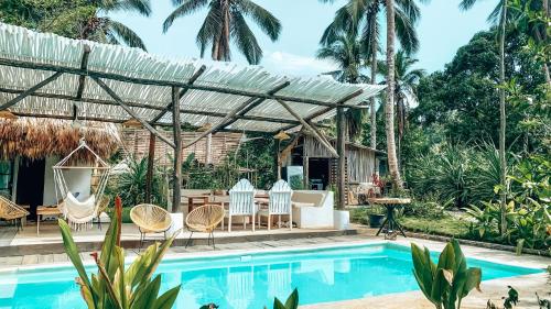 a pool with chairs and a pergola next to a house at La Colmena RD in Santa Bárbara de Samaná