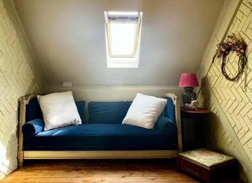 a blue couch in a room with a window at Eclectic Barn - Pergola & Dog-Friendly Garden in Calne