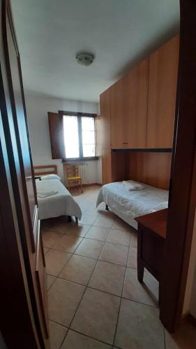 a bedroom with two beds and a table and a window at Residence San Francesco in Pomarance