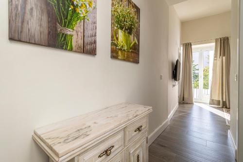 a white hallway with a wooden bench in a room at Casa Palacio Rufina & Jardines in Jerez de la Frontera