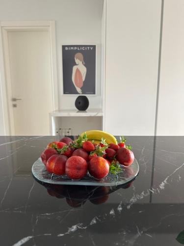 einen Teller Erdbeeren und Bananen auf dem Tisch in der Unterkunft Serena at Athens Riviera in Vari