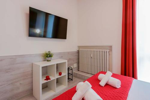 um quarto com uma cama vermelha e uma televisão na parede em Mirabilia Golden em Bolonha