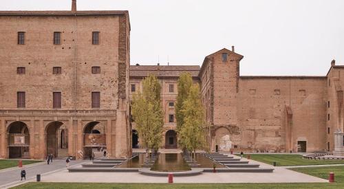 dziedziniec przed dużym budynku z cegły w obiekcie affittacamere emilia SELF CHECK IN w mieście Parma