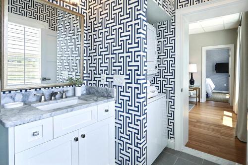 a bathroom with a sink and a wall with a pattern at El Rey Collection 1 in Tybee Island