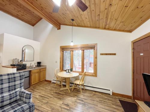 uma cozinha e sala de estar com mesa e cadeiras em Columbine B Cabin Suite em Woodland Park