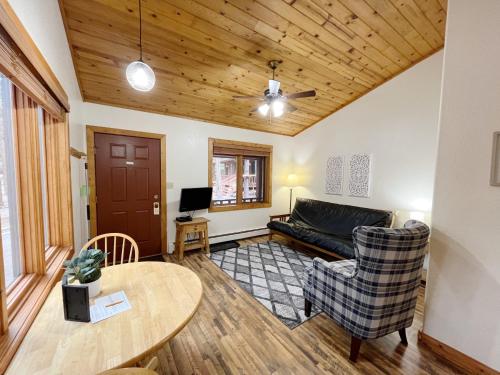 a living room with a couch and a table at Columbine B Cabin Suite in Woodland Park