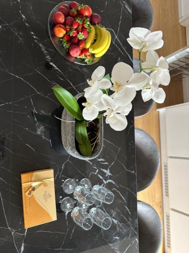 a black table with a vase of flowers and fruit at Serena at Athens Riviera in Vari