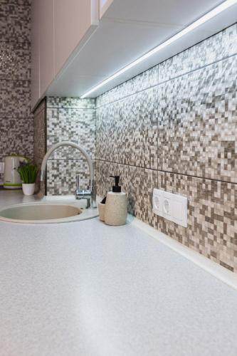 a bathroom with a sink and a brick wall at Aura Home in Dnipro