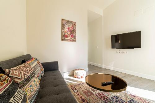 a living room with a couch and a coffee table at Casa Palacio Rufina & Jardines in Jerez de la Frontera