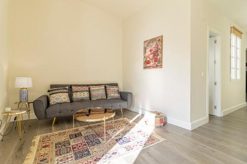 a living room with a couch and a table at Casa Palacio Rufina & Jardines in Jerez de la Frontera