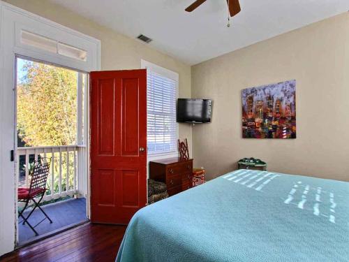 - une chambre avec un lit, une télévision et une fenêtre dans l'établissement Forsyth Park West Carriage House, à Savannah