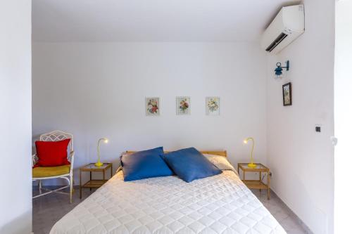 una camera da letto con un letto con cuscini blu e due sedie di Villa delle Ninfee by Napoliapartments ad Anacapri