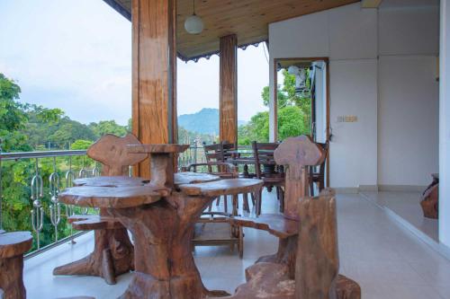 a porch with wooden tables and chairs on a balcony at Hotel Janara in Kurunegala