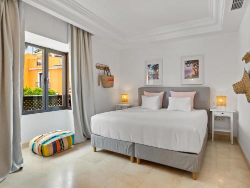 ein weißes Schlafzimmer mit einem großen Bett und einem Fenster in der Unterkunft Casa las Salinas in Marbella