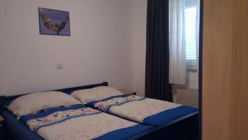 a bed with two pillows and a picture on the wall at Apartment Cizici ,Best Place 100m zum Meer, Soline bay, insel-krk,de in Čižići