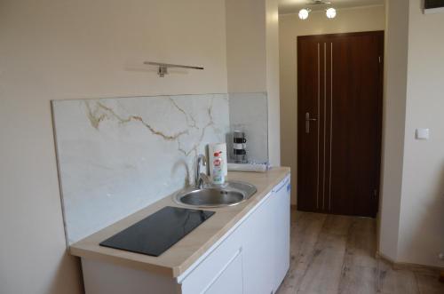 a bathroom with a sink and a marble wall at Magurka in Rycerka Górna