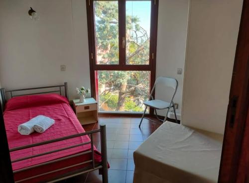a bedroom with a bed and a window and a chair at Villa Louise by Holiday World in Aci Castello
