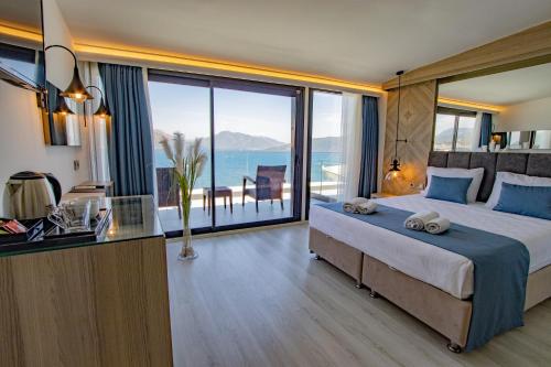 a bedroom with a large bed with a view of the ocean at Class Unique Beach in Marmaris