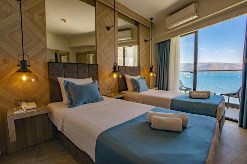 two beds in a room with a view of the ocean at Class Unique Beach in Marmaris