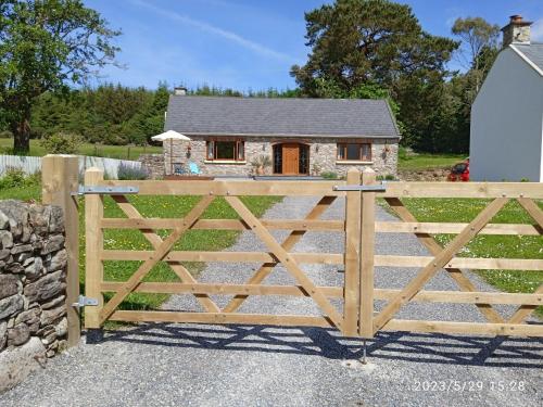 a wooden gate in front of a house at Nire Valley Cottage 
