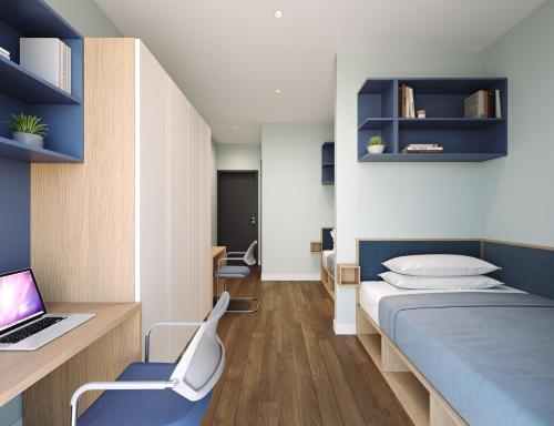 a bedroom with a bed and a laptop on a desk at Coleman Court Summer Accommodation in Cork