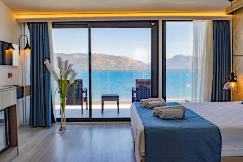 a hotel room with a bed and a view of the ocean at Class Unique Beach in Marmaris