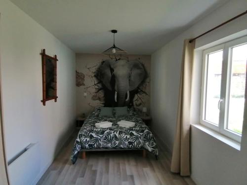 a bedroom with an elephant mural on the wall at Jungle Zen Beau T2 avec jardin Gare 100m in Tonneins