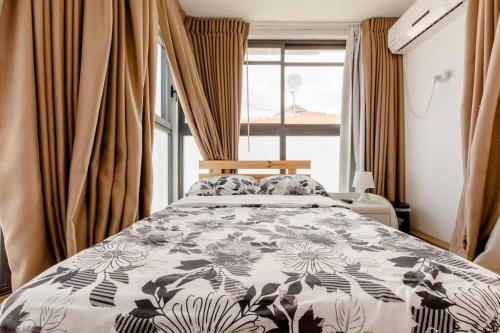 1 dormitorio con 1 cama con colcha de flores en Charming Unit with Pool and Great Amenities, en Rishon LeZion