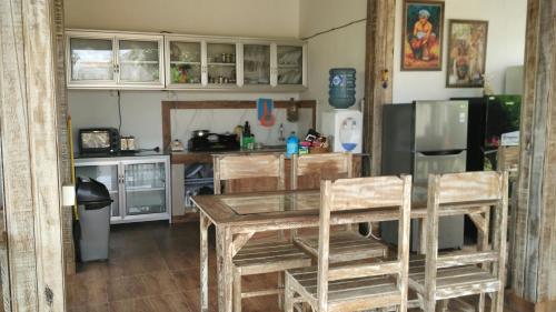 eine Küche mit einem Tisch und Stühlen sowie einem Kühlschrank in der Unterkunft Private room in Damar Bali Guest house in Kerobokan