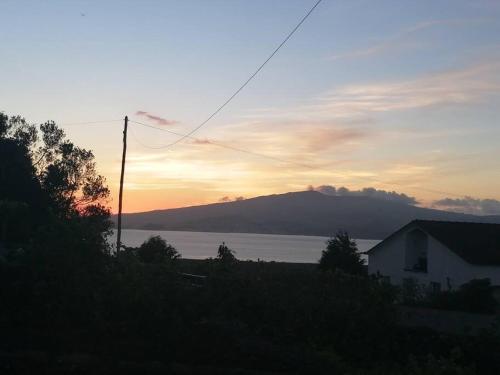 a sunset over a body of water with a mountain at Dream View in Pico in Criação Velha